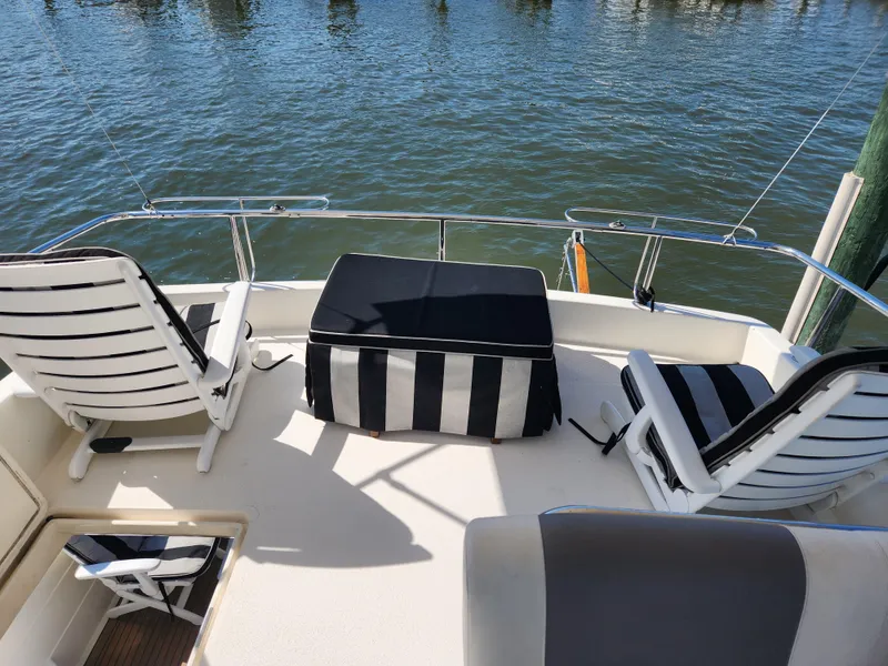 Slide: The Image of Posillipo Technema 52 yacht deck with striped seating, 1987 model, overlooking water. - 19