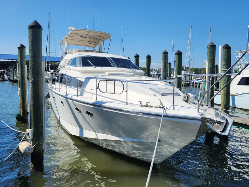 Slide: The Image of 1987 Posillipo Technema 52 yacht docked at marina under clear blue sky. - 2