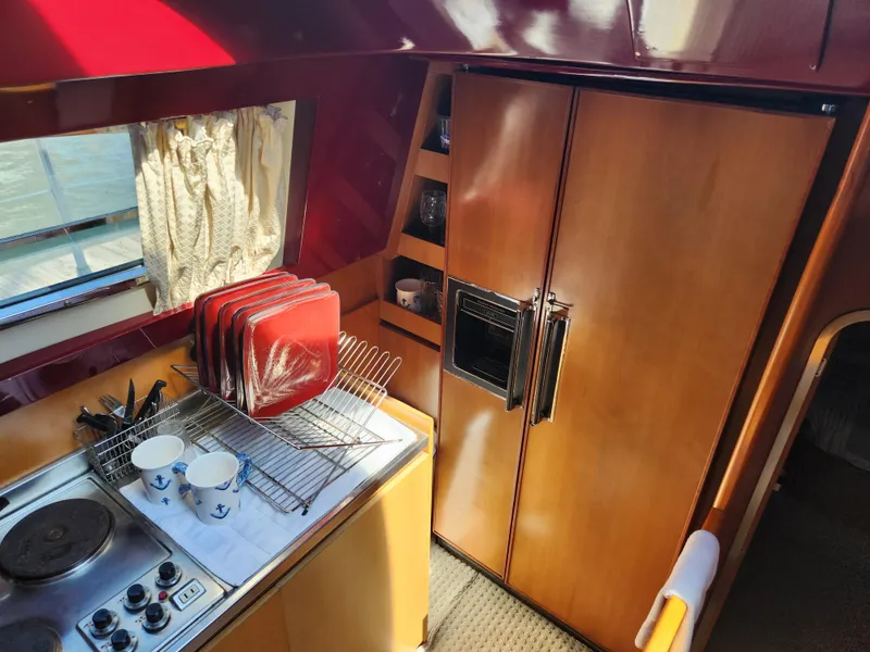Slide: The Image of Interior of 1987 Posillipo Technema 52 yacht kitchen with stove, dishes, and wooden cabinets. - 34