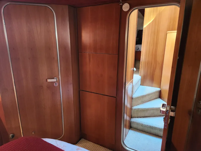 Slide: The Image of Interior of 1987 Posillipo Technema 52 yacht with wooden paneling and carpeted stairs. - 41