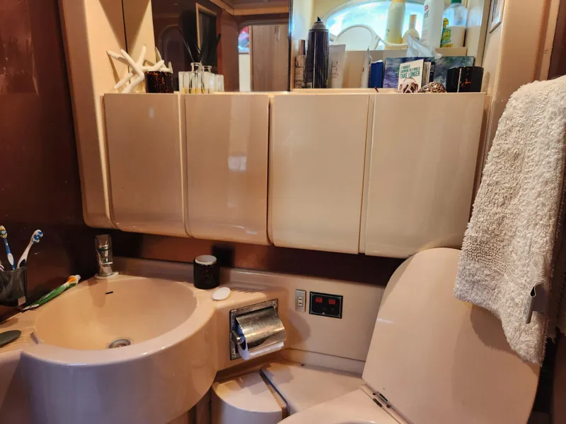 Slide: The Image of Bathroom interior of a 1987 Posillipo Technema 52 yacht, featuring beige fixtures and storage cabinets. - 42
