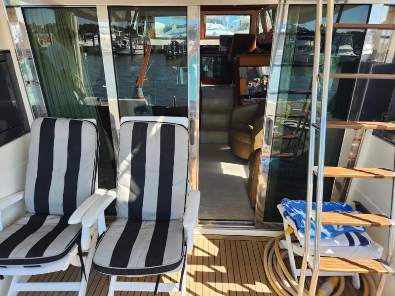 Slide: The Image of Deck of 1987 Posillipo Technema 52 yacht with striped chairs and wooden steps. - 49