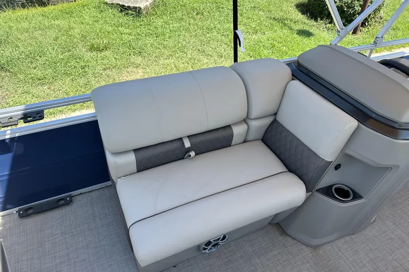 Slide: The Image of 2025 Sun Tracker Fishin' Barge 22 DLX interior seating with cup holder and storage. - 15