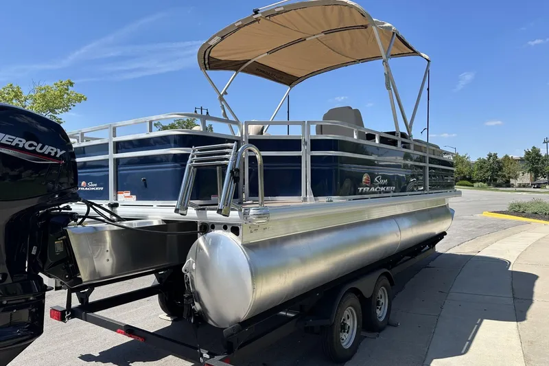 Slide: The Image of 2025 Sun Tracker Fishin' Barge 22 DLX pontoon boat with canopy on trailer. - 5