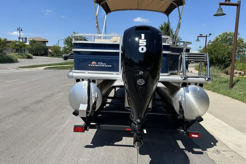 Slide: The Image of 2025 Sun Tracker Fishin' Barge 22 DLX pontoon boat with 150 HP engine on trailer. - 3
