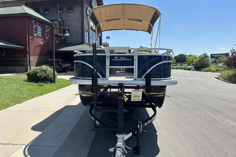 Slide: The Image of 2025 Sun Tracker Fishin' Barge 22 DLX pontoon boat parked on a trailer. - 7