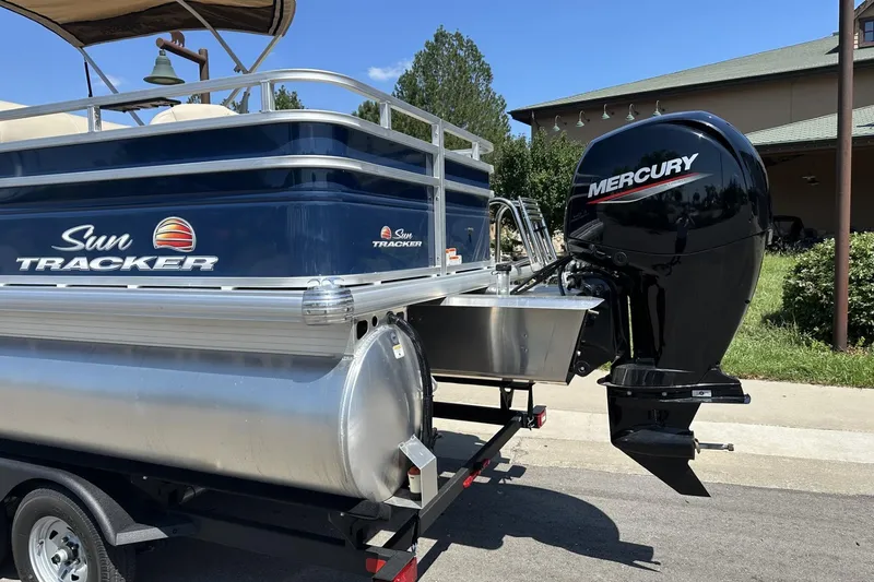 Slide: The Image of 2025 Sun Tracker Fishin' Barge 22 DLX with Mercury outboard motor on trailer. - 2