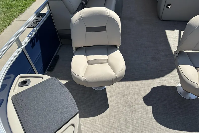 Slide: The Image of 2025 Sun Tracker Fishin' Barge 22 DLX interior with beige seating and fishing station. - 9