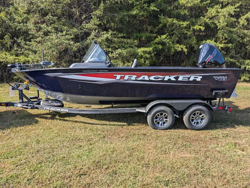 The Image of 2025 Tracker Targa V-19 WT boat on trailer, parked on grass with trees in background. - 0