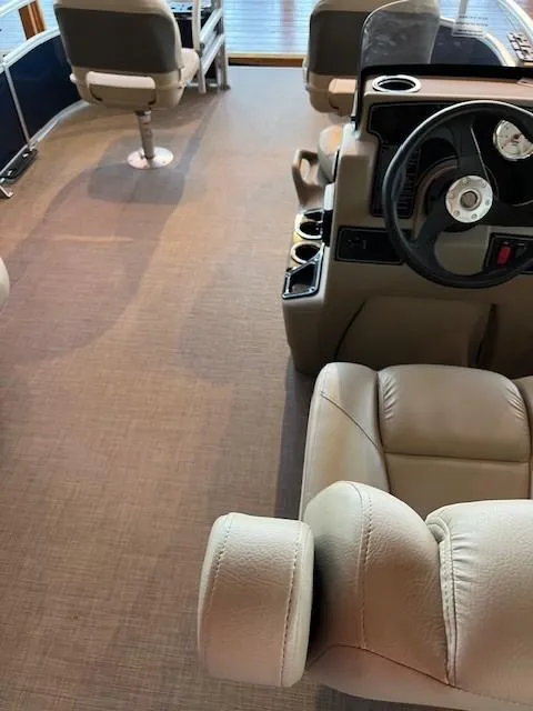Slide: The Image of Interior of 2025 Sun Tracker Bass Buggy 16 XL Select with beige seating and steering console. - 2