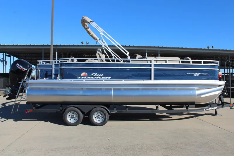 The Image of 2025 Sun Tracker Fishin' Barge 22 DLX pontoon boat on trailer, side view. - 0