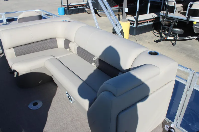 Slide: The Image of 2025 Sun Tracker Fishin' Barge 22 DLX with beige seating and cup holders. - 14