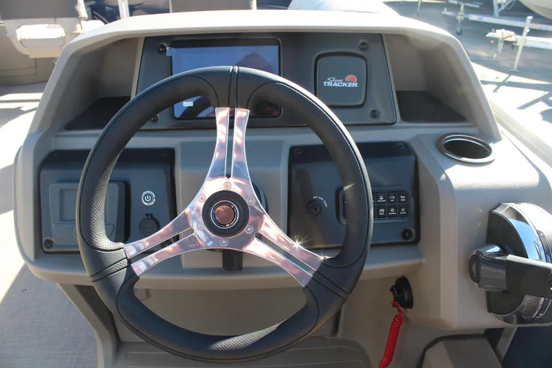 Slide: The Image of 2025 Sun Tracker Fishin' Barge 22 DLX steering console with modern controls and display. - 16