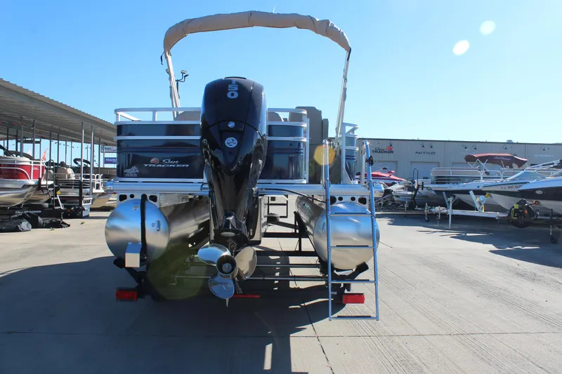 Slide: The Image of 2025 Sun Tracker Fishin' Barge 22 DLX pontoon boat at a marina. - 2