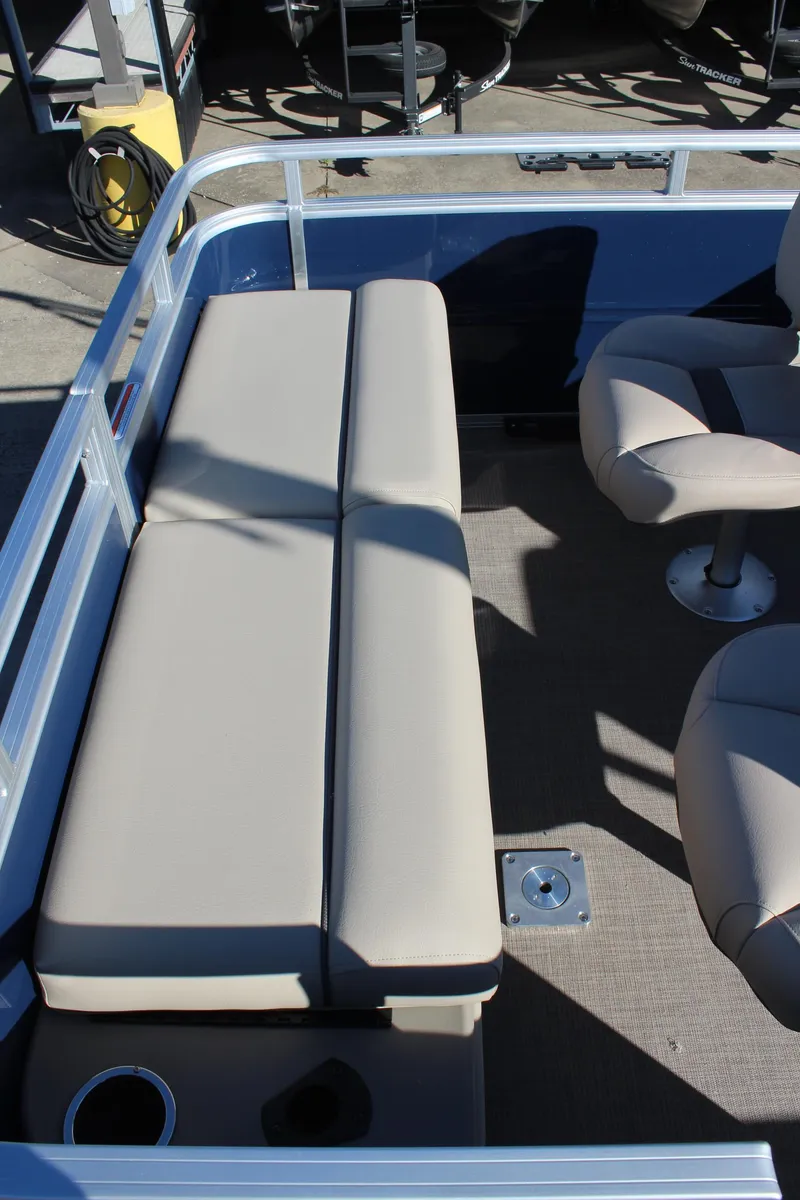 Slide: The Image of 2025 Sun Tracker Fishin' Barge 22 DLX interior with beige seating and carpeted floor. - 20
