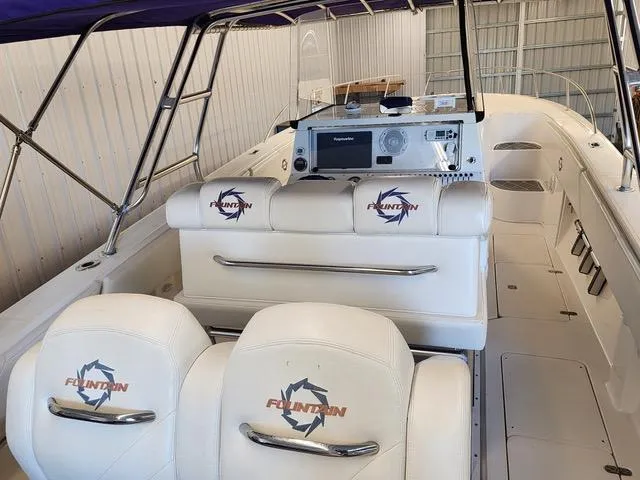Slide: The Image of 2003 Fountain 38 Center Console boat interior with white seating and navigation equipment. - 11