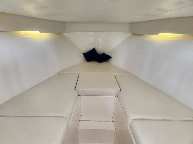 Slide: The Image of 2003 Fountain 38 Center Console cabin interior with white seating and ambient lighting. - 12