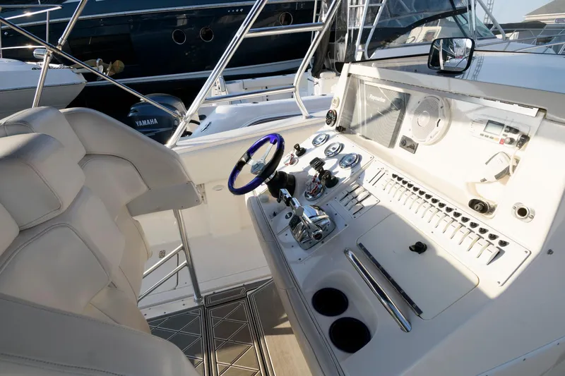 Slide: The Image of 2003 Fountain 38 Center Console boat cockpit with steering wheel and control panel. - 19