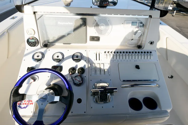 Slide: The Image of 2003 Fountain 38 Center Console boat dashboard with steering wheel and control panel. - 20
