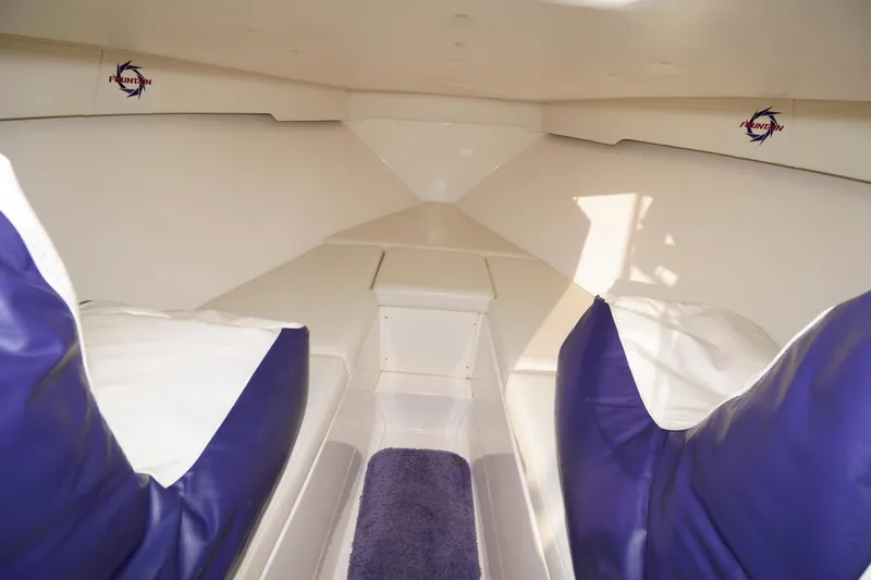 Slide: The Image of Interior of a 2003 Fountain 38 Center Console boat with purple and white seating. - 22