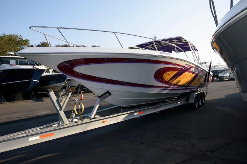 Slide: The Image of 2003 Fountain 38 Center Console boat on trailer, vibrant graphics, parked outdoors. - 5