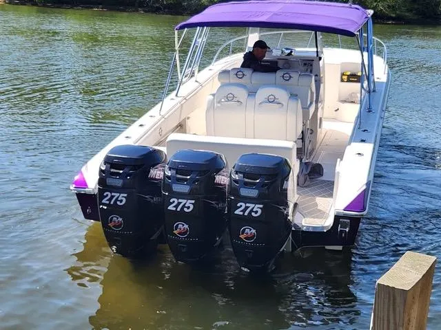 Slide: The Image of 2003 Fountain 38 Center Console boat with triple 275 horsepower engines on a calm lake. - 6