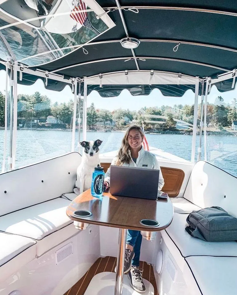 Slide: The Image of Woman working on a laptop with a dog on a 2020 Duffy Suncruiser 22 boat. - 10