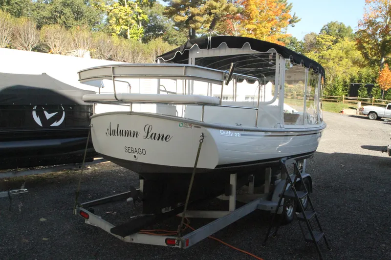 Slide: The Image of 2020 Duffy Suncruiser 22 boat on trailer, named "Autumn Lane," in a scenic outdoor setting. - 4