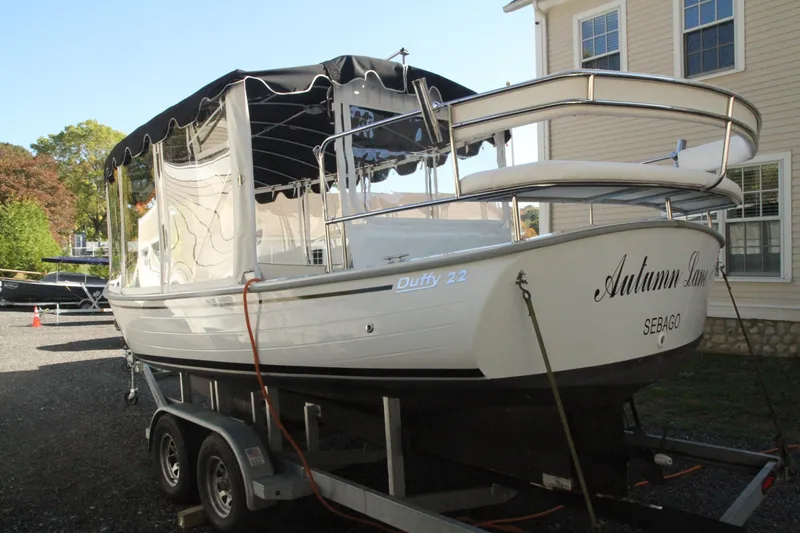 Slide: The Image of 2020 Duffy Suncruiser 22 boat on trailer, parked near a house. - 5