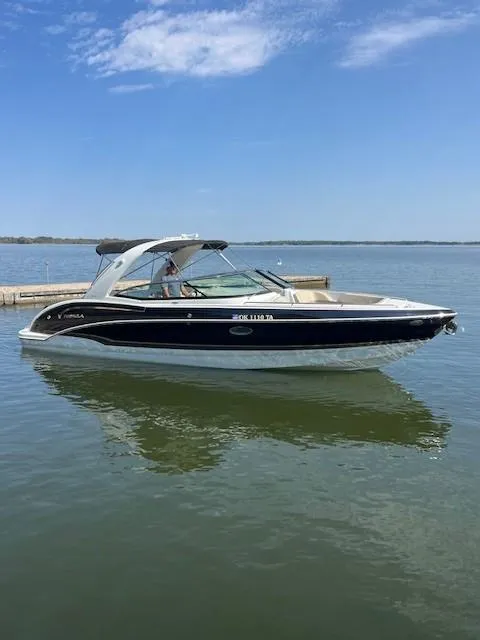 Slide: The Image of 2012 Formula 310 Bowrider I/O boat on calm lake under clear blue sky. - 8
