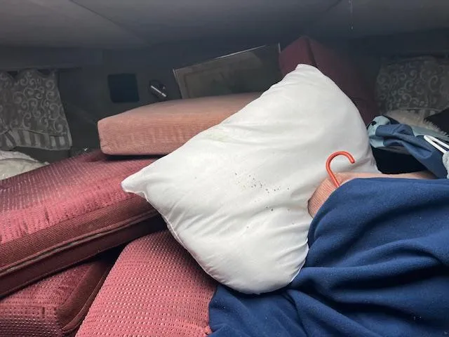 Slide: The Image of Interior of 1985 Trojan 11 Meter Express with cushions, pillow, and clothing. - 10