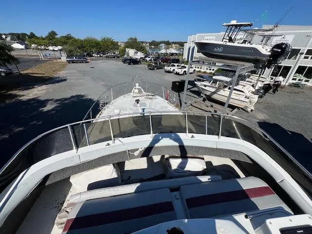 Slide: The Image of 1985 Trojan 11 Meter Express boat on land, viewed from the deck, with surrounding boats and vehicles. - 18
