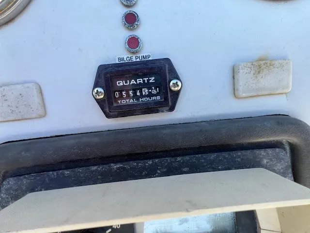 Slide: The Image of 1985 Trojan 11 Meter Express dashboard with hour meter and bilge pump indicator. - 19