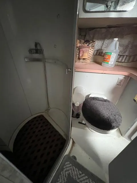 Slide: The Image of 1985 Trojan 11 Meter Express bathroom with shower, toilet, and storage shelves. - 8
