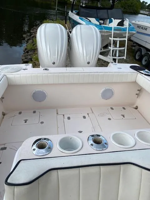 Slide: The Image of 2002 Intrepid 323 Cuddy boat interior with twin engines and seating area. - 13