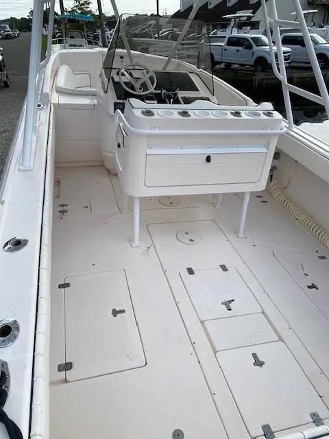 Slide: The Image of 2002 Intrepid 323 Cuddy boat interior with steering console and storage compartments. - 14
