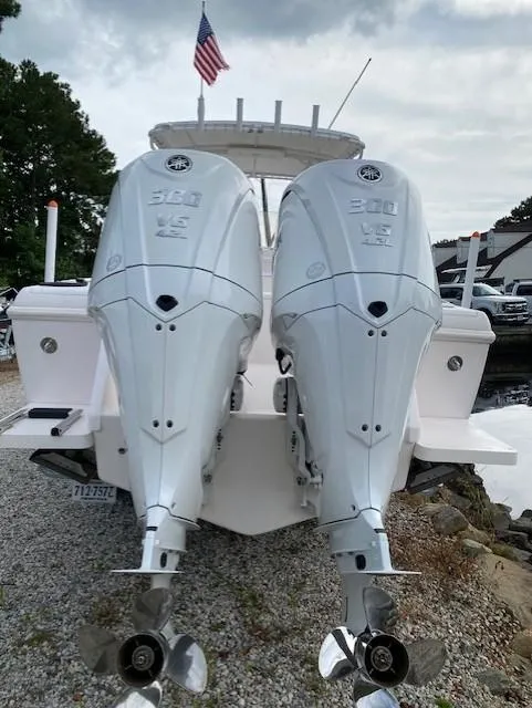 Slide: The Image of 2002 Intrepid 323 Cuddy with twin 300 HP engines, docked on gravel. - 15