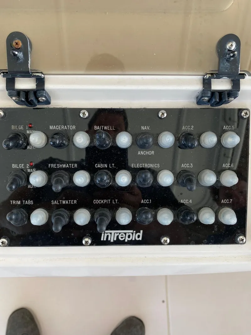Slide: The Image of Control panel of a 2002 Intrepid 323 Cuddy boat with labeled switches. - 17