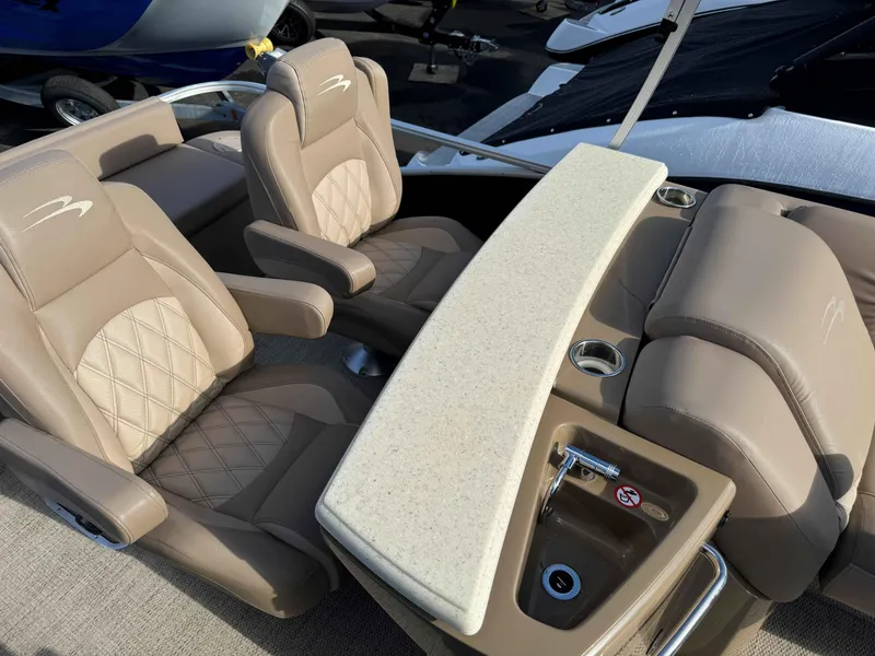 Slide: The Image of 2018 Bennington R25 boat interior with beige leather seats and a built-in sink. - 8