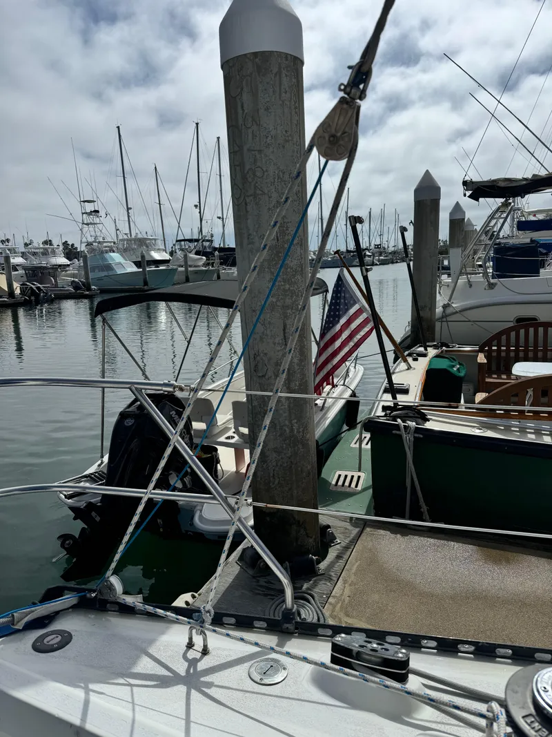 Slide: The Image of 1985 C&C 41 sailboat docked in marina with American flag. - 13