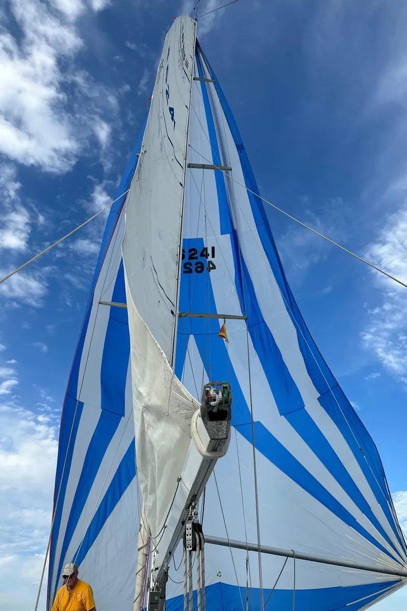 Slide: The Image of 1985 C&C 41 sailboat with blue and white sails against a blue sky. - 26