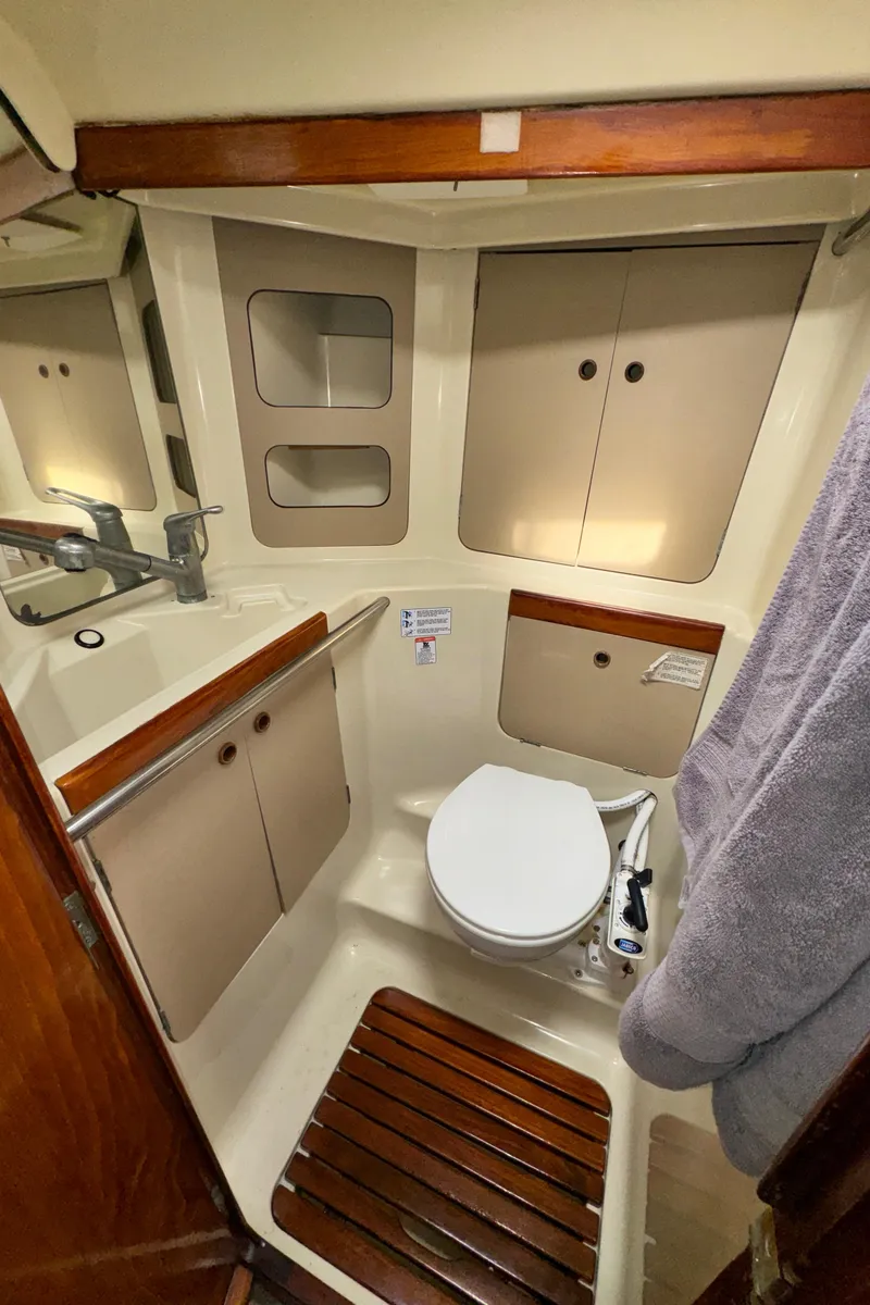 Slide: The Image of 1985 C&C 41 yacht bathroom with toilet and storage cabinets. - 40