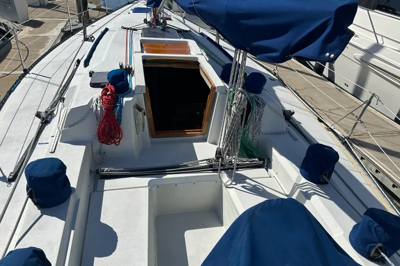 Slide: The Image of 1985 C&C 41 sailboat with blue covers docked at marina. - 6