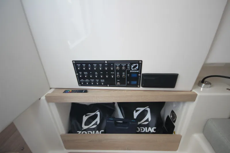 Slide: The Image of Control panel of 2026 Zodiac X10CC boat with storage compartment and branded bags. - 27
