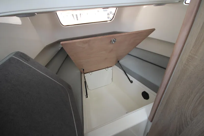 Slide: The Image of Interior cabin storage of 2026 Zodiac X10CC boat, featuring a wooden hatch and seating. - 29