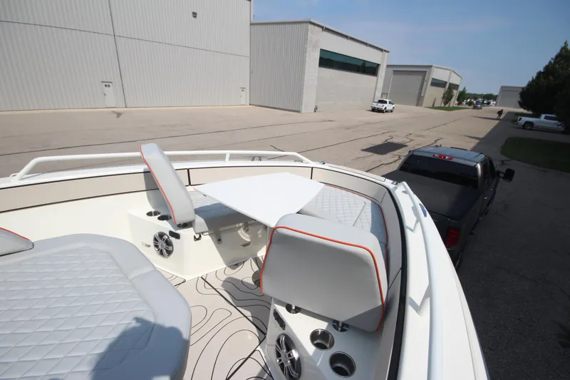 Slide: The Image of 2026 Zodiac X10CC boat interior with seating and table, parked near industrial buildings. - 33