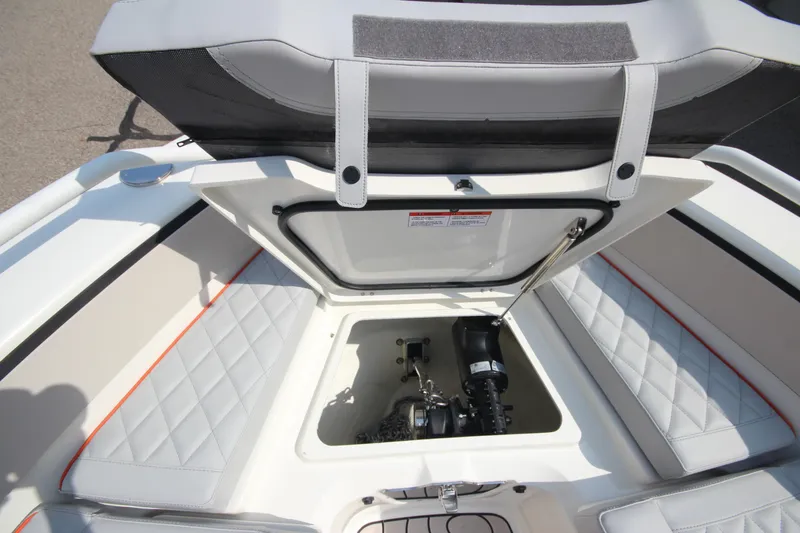 Slide: The Image of 2026 Zodiac X10CC boat storage compartment with cushioned seating and visible engine components. - 35