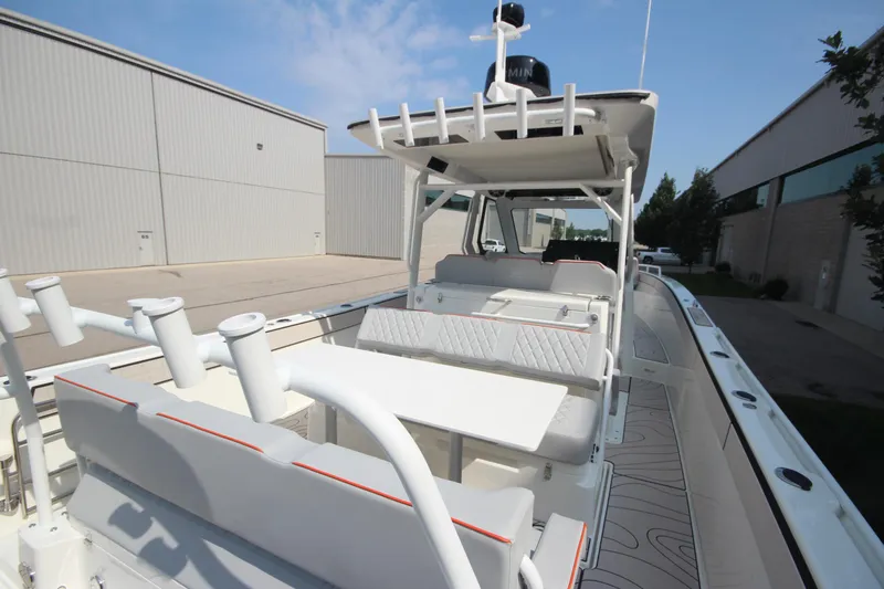 Slide: The Image of 2026 Zodiac X10CC boat with seating, table, and rod holders, docked near industrial buildings. - 9