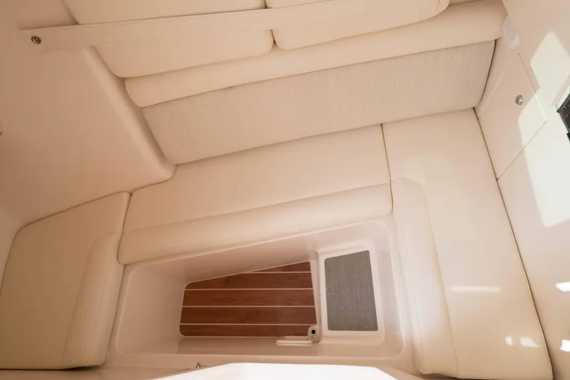 Slide: The Image of 2025 Grady-White Freedom 325 interior cabin with cushioned seating and wooden flooring. - 16
