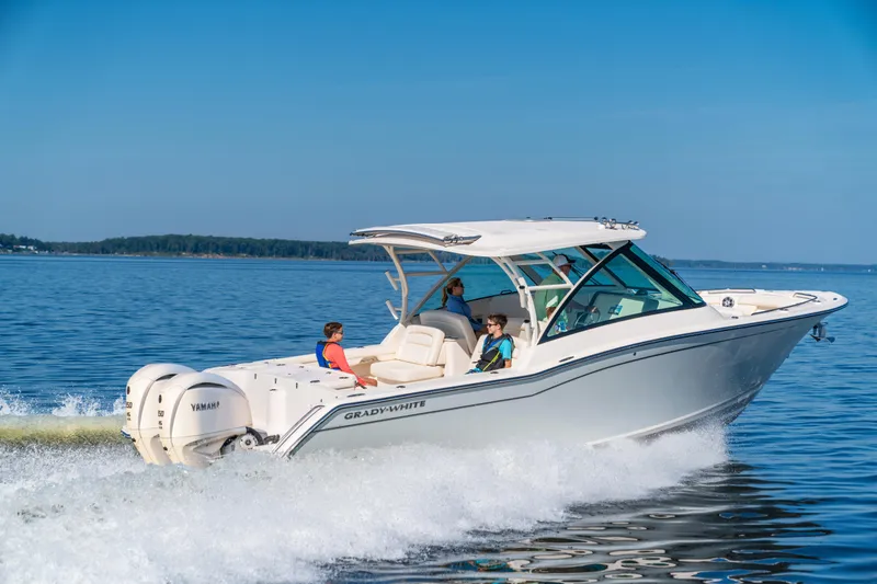 Slide: The Image of 2025 Grady-White Freedom 325 boat cruising on open water, clear blue sky. - 3